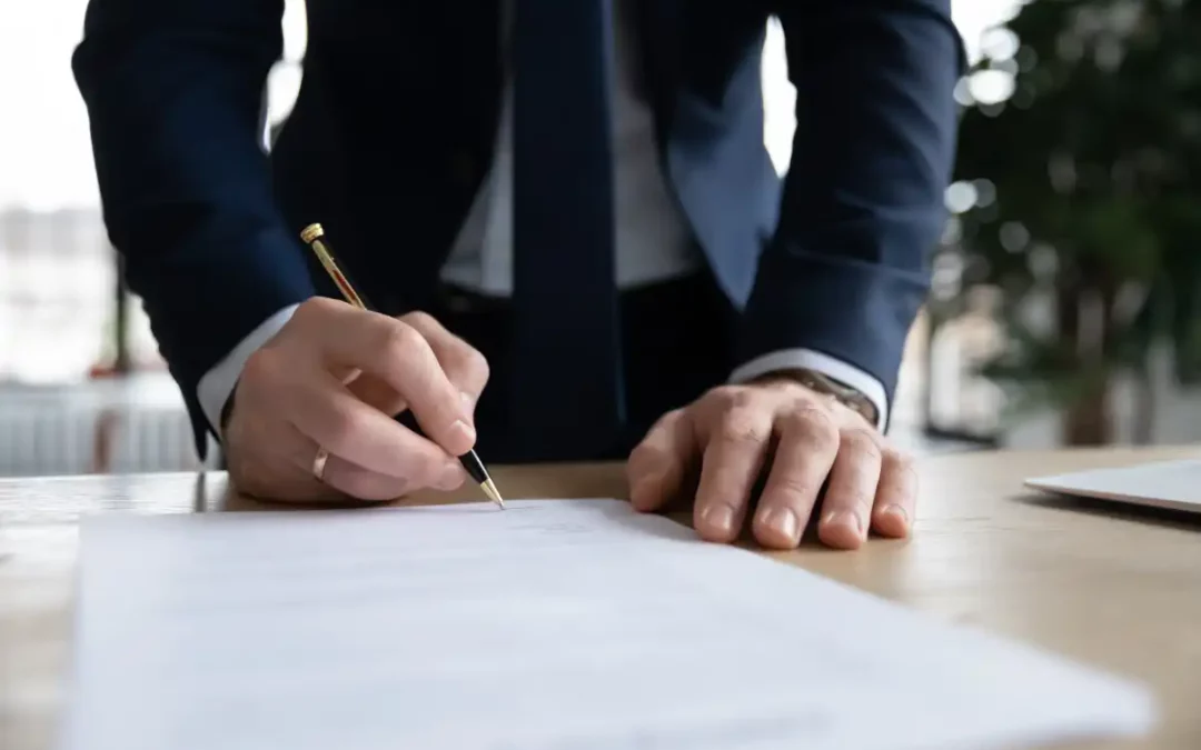 patron en costume de bureau mettre la signature sur le contrat de rémunération commerciaux